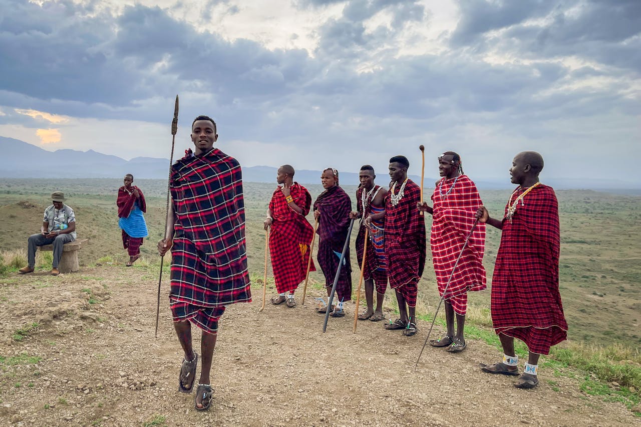A group of Maasai men in colorful traditional garments in the scenic landscapes of Arusha, Tanzania.